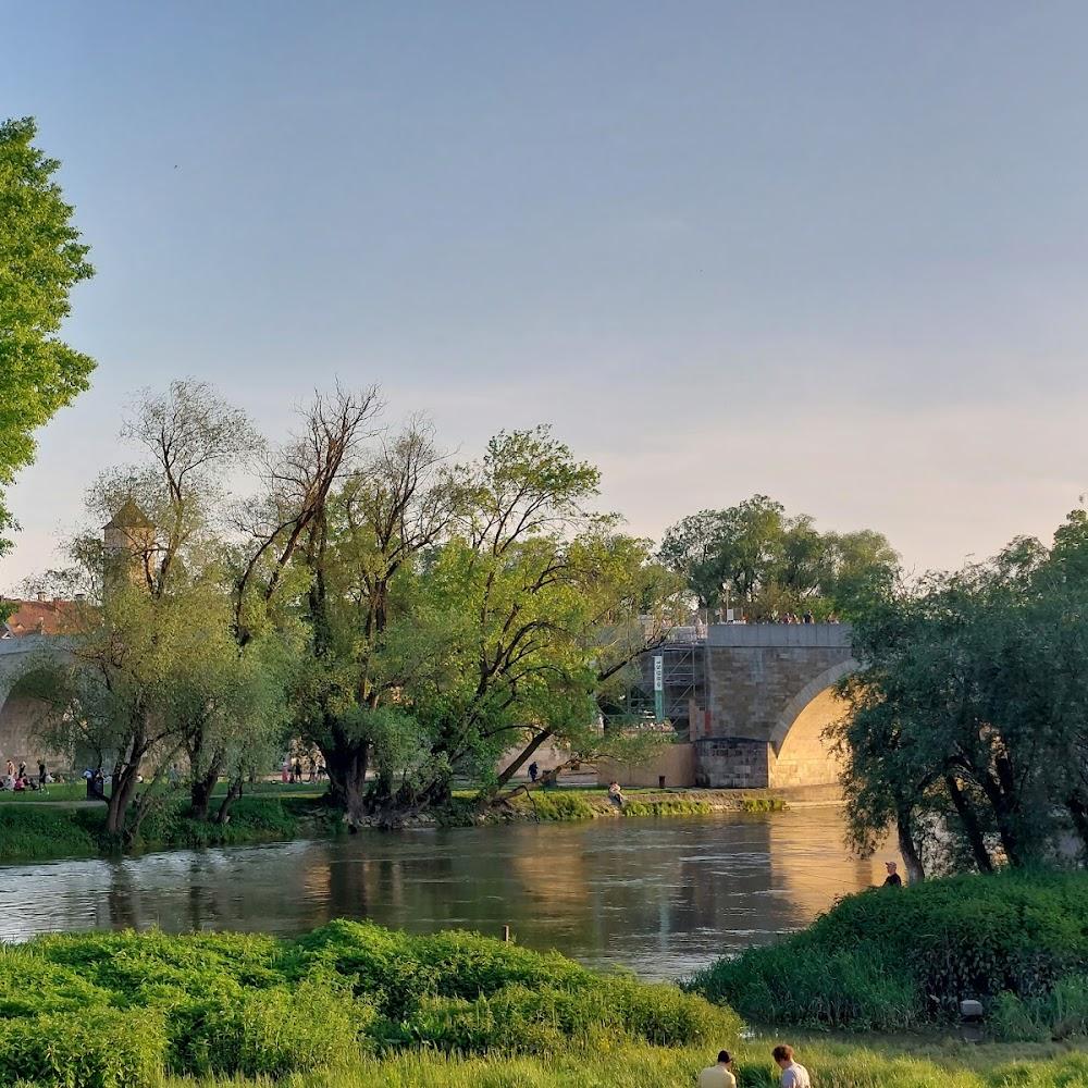 Stone bridge over a river with trees.
